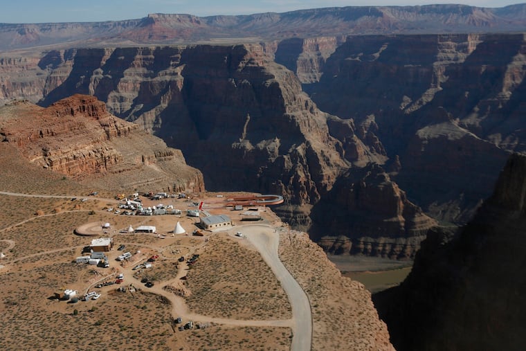 FILE - In this March 20, 2007, file photo, the Skywalk hangs over the Grand Canyon on the Hualapai Indian Reservation before its grand opening ceremony at Grand Canyon West, Ariz. Crews are searching for a tourist who slipped and fell over the edge of a Grand Canyon lookout on tribal land. The fall happened Thursday, March 28, 2019, morning on the Hualapai Tribe's reservation outside the boundaries of Grand Canyon National Park.