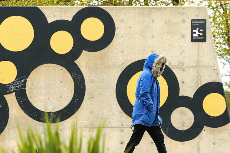 How quickly we forget how chilly April can be. A walker bundles up for the unseasonably cold weather on the way around the track on Central Green at The Navy Yard in Philadelphia last April 22.
