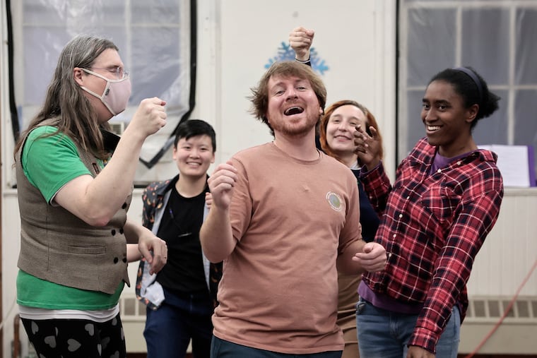 From left, in back: Pandora Beatrix, Mark Tan, Rosalie Hooper, and Liyah Jefferson surround Nick Perrone, who portrays William Henry Harrison, while rehearsing a scene from ”William Henry Harrison: The Musical” at the Community Education Center in Philadelphia on Thursday, April 30, 2026.