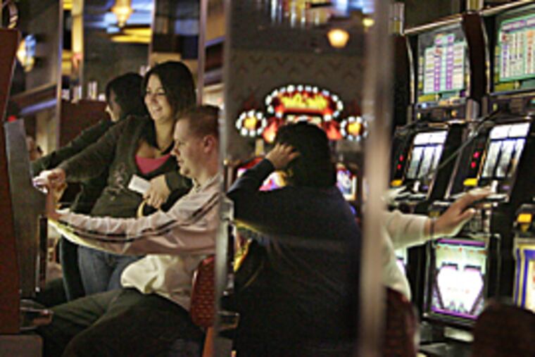 Larry Krayn, 22, and Krystal Longo of Freehold, NJ play a quarter slot machine at Resorts Casino in Atlantic City. (Elizabeth Robertson / Inquirer Staff)