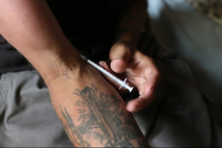 Josh Green removes the needle after injecting heroin in his arm inside the former Ascension of Our Lord church in Philadelphia, PA on July 5, 2017.