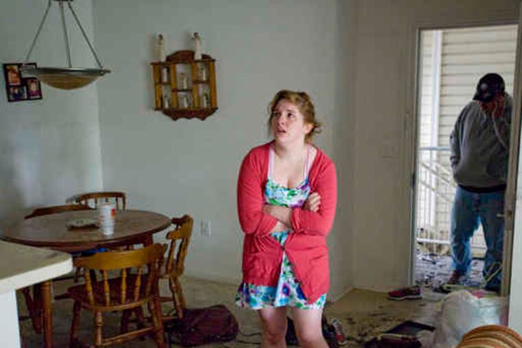 Tiffany Wegman surveys her apartment after the fire was extinguished at the Millview Apartment Homes. She and her husband and two children will be staying with her parents for now.