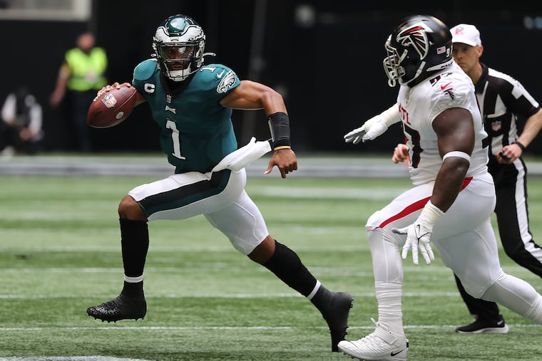 Philadelphia Eagles quarterback Jalen Hurts scrambles away from Atlanta Falcons defensive tackle Grady Jarrett during the second quarter.