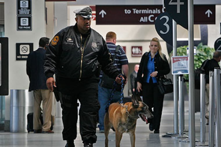 In a reassuring routine, K9 Officer Terry Wright patrols an airport concourse with Rex. (Alejandro A. Alvarez / Staff Photographer)