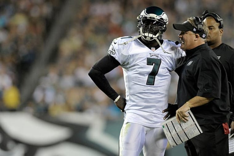Philadelphia Eagles head coach Chip Kelly talks to Michael Vick during a preseason NFL football game against the Carolina Panthers on Thursday, Aug. 15, 2013, in Philadelphia. (AP Photo/Michael Perez)