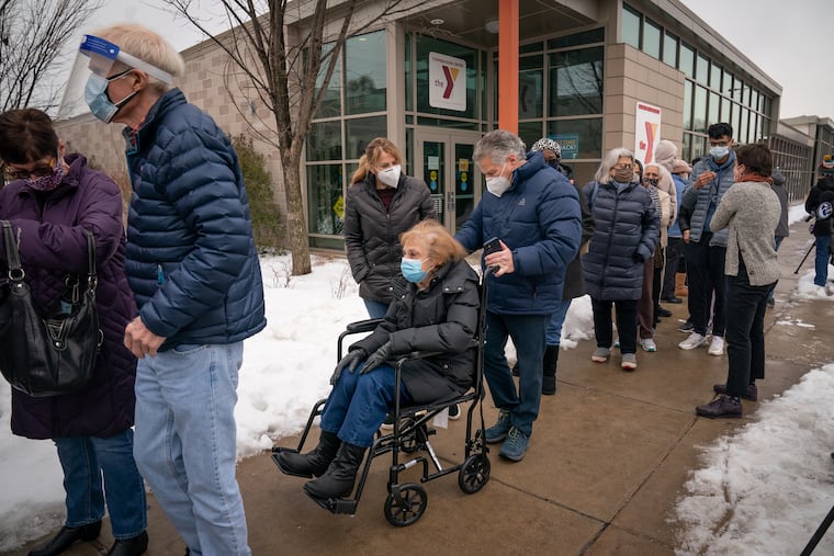 Dorothy Miller 83, seated in a wheelchair, waits in line with her daughter, Beth Feldman (back center), and her son-in-law, Paul Feldman (right center), as they wait in line to be vaccinated at the Martin Luther King Jr. Older Adult Center, one of three clinics that can vaccinate up to 500 people each per day, in Philadelphia, Tuesday, Feb. 23, 2021.