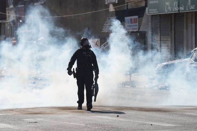 A police officer walks near 52nd and Chestnut Streets in Philadelphia on Sunday.