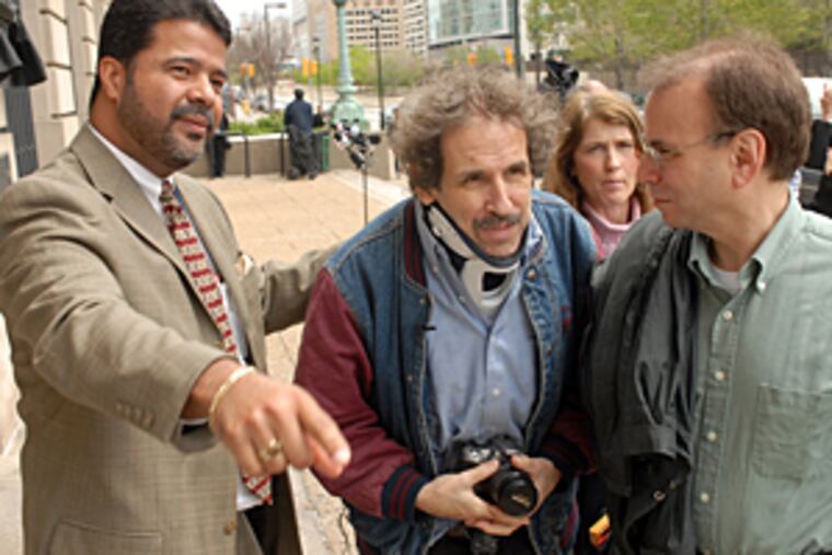 Prosecutor Angel Flores, left, leads Germantown High School teacher
Frank Burd, center, to his driver outside Family Court today. Burd spoke to two students for the first time since they attacked him, during their sentencing in Juvenile Court on aggravated assault charges.