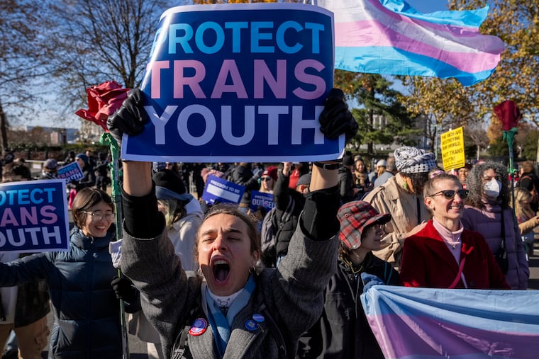 A young person who preferred not to give her name cheers as supporters of transgender rights rally by the U.S. Supreme Court Building on Dec. 4, 2024, as arguments begin in a case regarding a Tennessee law banning gender-affirming medical care for transgender youth.