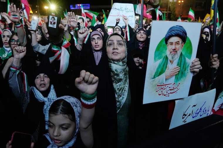 Pro-government demonstrators chant slogans as one of them holds a poster of the Iranian Supreme Leader Ayatollah Mojtaba Khamenei during their gathering at Enqelab-e-Eslami, or Islamic Revolution, square in Tehran on May 4.