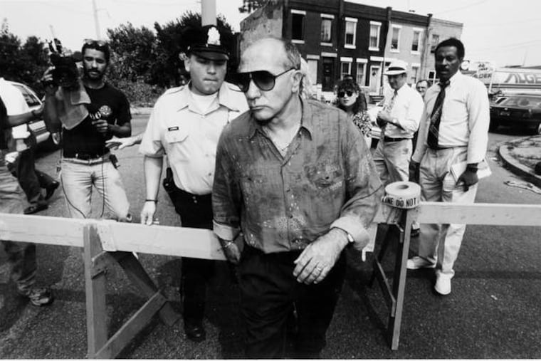 John Stanfa crosses a police line in front of his business, Continental Foods in South Philadelphia.
