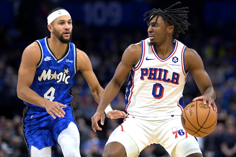 Philadelphia 76ers guard Tyrese Maxey (0) is defended by Orlando Magic guard Jalen Suggs (4) during the first half. Maxey scored 32 points in the win.
