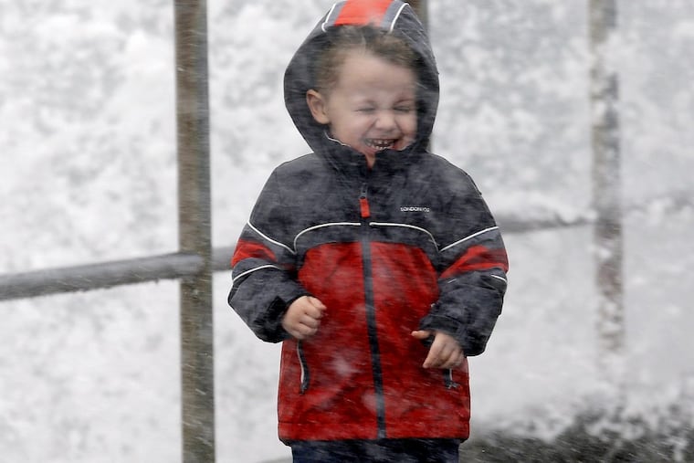 Archer Christiansen, 3, braces himself against wind and a breaking wave as he walks with his parents in a windstorm along the Puget Sound in Washington on Monday.