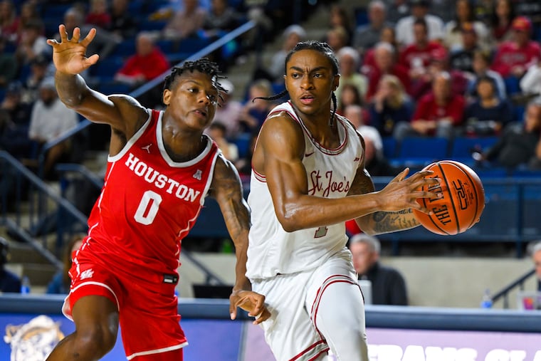 St. Joseph's guard Christian Winborne drives to the basket against Houston's Marcus Sasser during a game last season.