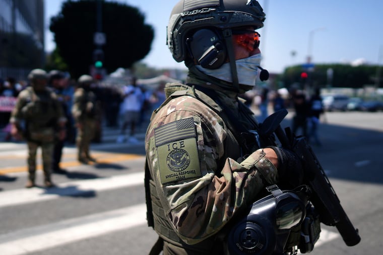 FILE - An ICE Special Response Team member stands guard outside the Metropolitan Detention Center, while protesters gather outside to denounce the ICE, U.S. Immigration and Customs Enforcement, operations, June 10, 2025, in downtown Los Angeles.