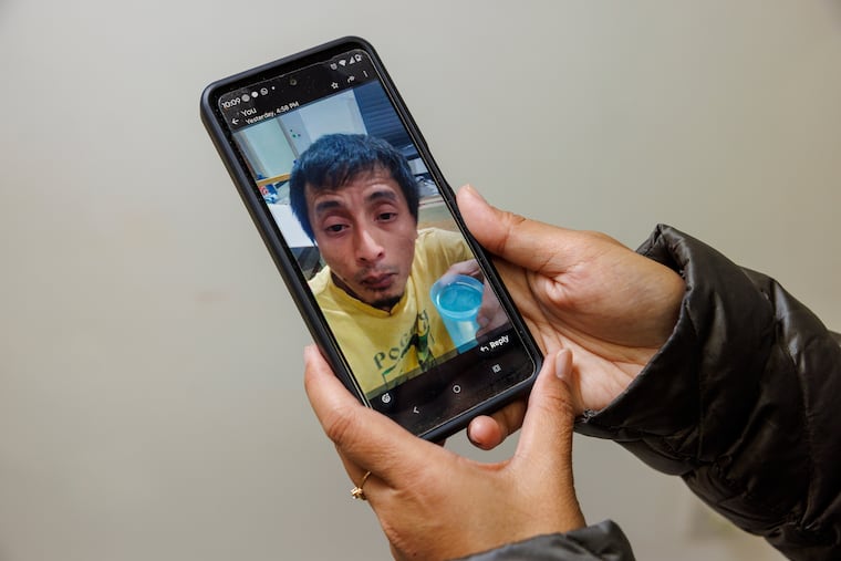 Siti Rahayu of Philadelphia holds a photograph of her husband Rian Andrianzah. He walked into United States Citizenship and Immigration Services office for a routine visit but was sent to Moshannon detention center to await deportation.