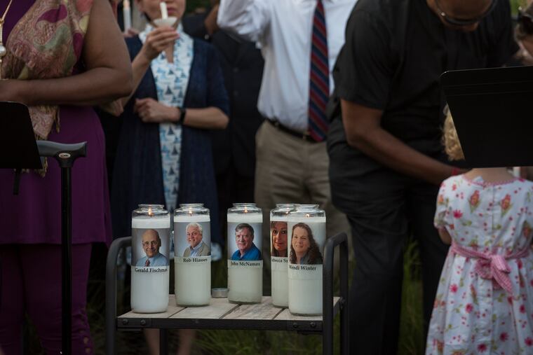 Candles are lit for the five staffers killed by a gunman at the Capital Gazette office building at an interfaith vigil across the street from the building in Annapolis, Md. on Friday, June 29, 2018.