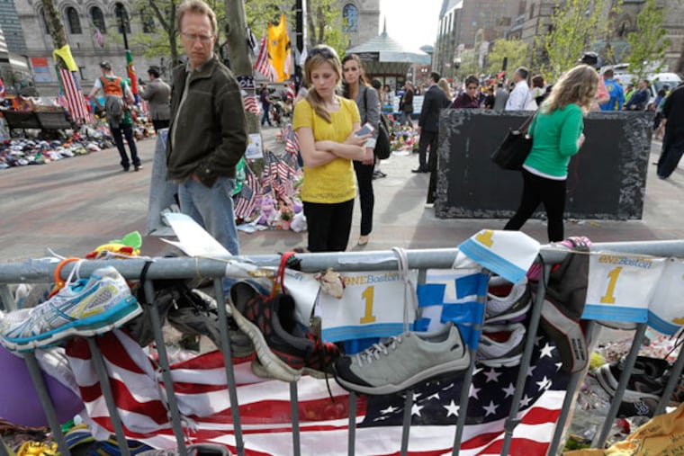 People pause to look at a makeshift memorial near the Boston Marathon finish line in Boston's Copley Square Tuesday, May 7, 2013 in remembrance of the Boston Marathon bombings. (AP Photo/Steven Senne)