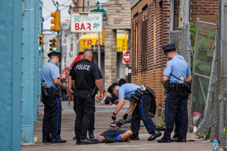 Philadelphia police attend to a man on the sidewalk during their patrol along Kensington Avenue on Wednesday, June 19, 2024, where fentanyl use is common. A new adulterant in the street fentanyl supply is medetomidine.