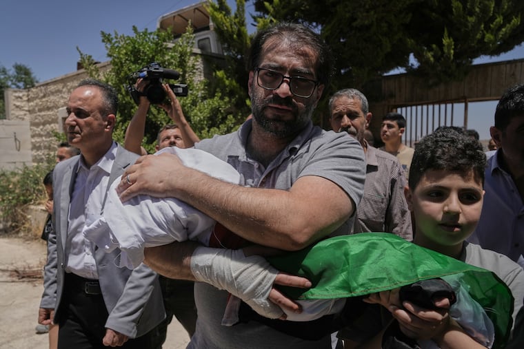 Fahd Abu Haikal, 41, carries the body of his 7-month-old son Sam, who was killed on Friday when, according to the Palestinian health ministry, Israeli soldiers fired at the vehicle carrying him and his parents in Tel Rumeida, during the boy's funeral in the West Bank city of Hebron, Saturday, June 6, 2026.