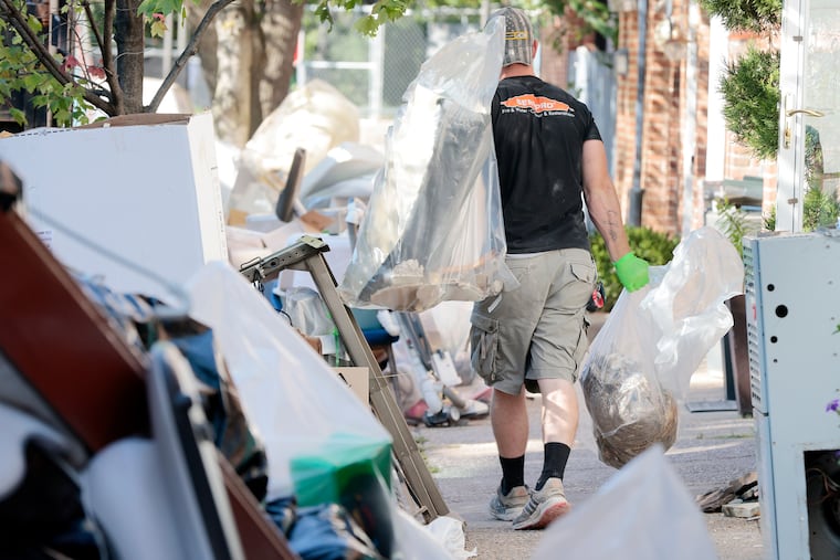 On South Taney Street in Center City Philadelphia Saturday, Servpro Society Hill employees haul away items ruined by flooding from the remnants of Hurricane Ida. On Sunday, the city issued a list of resources for storm victims and safety warnings.