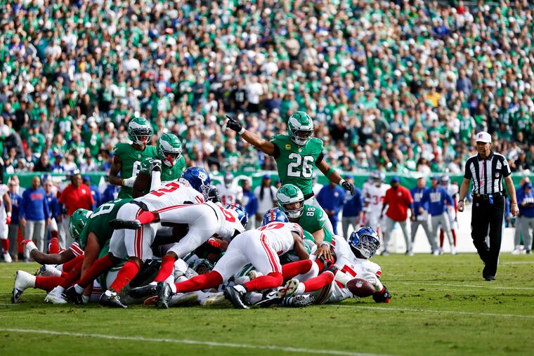 Eagles running back Saquon Barkley signals first down after quarterback Jalen Hurts gains one yard on a Tush Push against the Giants. The play was challenged by Giants head coach Brian Daboll, as the ball appeared to be stripped from Hurts before he was down.