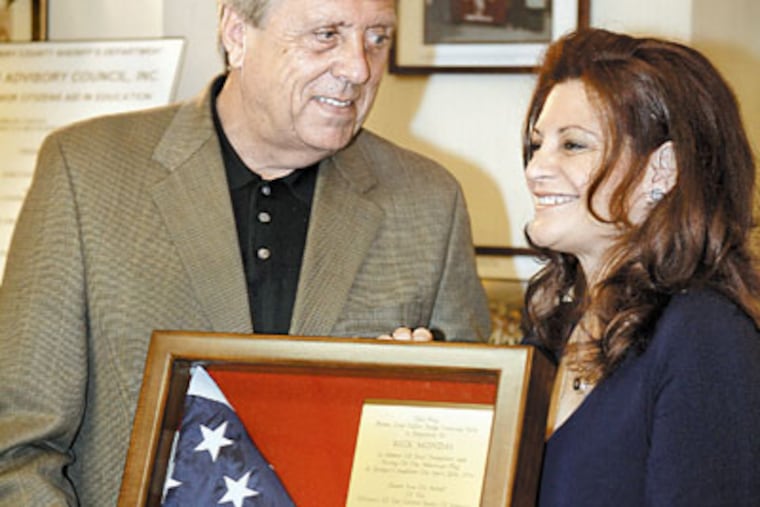 Ex-Chicago Cub Rick Monday and wife Barbara Lee Casciari-Monday show the flag that was presented to them during a Montco luncheon. (Akira Suwa/Inquirer)