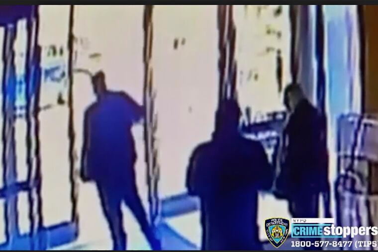This image taken from surveillance video provided by the New York City Police Department shows an apartment building employee closing the building's front door after a man assaulted a 65-year-old Asian American woman on March 29.