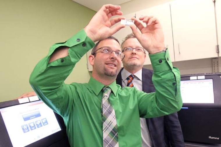 Robert Daber, left, technical director of clinical genomics at Penn's Center for Personalized Diagnostics, and David B. Roth, chairman of the department of Pathology and Laboratory Medicine at Penn Medicine, look over a flow cell checking for any flaws in it. The flow cell contains DNA from a tumor cell and will be inserted in a MiSeq from Illumina, left and right, which is used to conduct gene
sequencing. Hospital of the University of Pennsylvania has now joined the growing ranks of top medical centers that are doing extensive genetic testing of their patients' cancers. Cancer doctors say this will lead to more individualized treatment and it has the potential to spare patients from the side effects of treatments that won't work and steer them more quickly toward the best bets. It's also changing the way doctors think about cancer, making its location less important than its genetic makeup. ( CHARLES FOX / Staff Photographer )