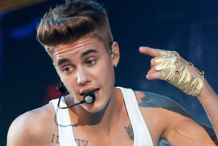 FILE - This March 19, 2013 file photo shows Canadian singer Justin Bieber performing during a concert at Bercy arena in Paris. Sheriff’s deputies are investigating Bieber for yet another dispute with a neighbor that land him in court. Los Angeles County Sheriff’s spokesman Steve Whitmore said Bieber has been named as a suspect in a misdemeanor vandalism and assault crime report for allegedly throwing eggs at a neighbor’s home in their gated Calabasas neighborhood Thursday, Jan. 9, 2014. (AP Photo/Francois Mori, file)