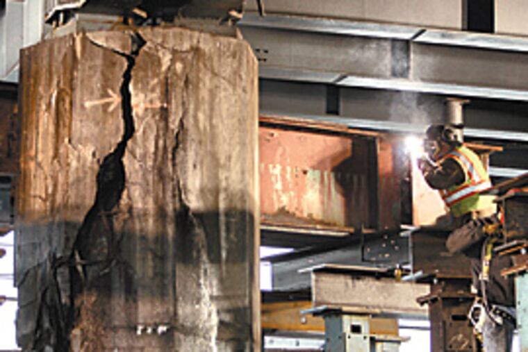 A PennDOT crew works Wednesday on constructing the buttresses to support a cracked column underneath I-95 in Port Richmond. (Michael Perez/Inquirer)