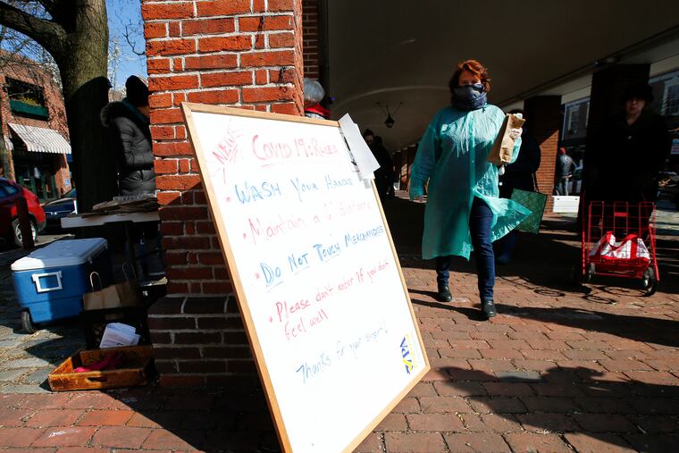 A board with a list of rules for shoppers at the Headhouse Farmers' Market in the Society Hill section of Philadelphia on Sunday, March 22, 2020. The market is open even after Gov. Tom Wolf called for the closure of all businesses that are not "life-sustaining," due to the spread of the coronavirus.