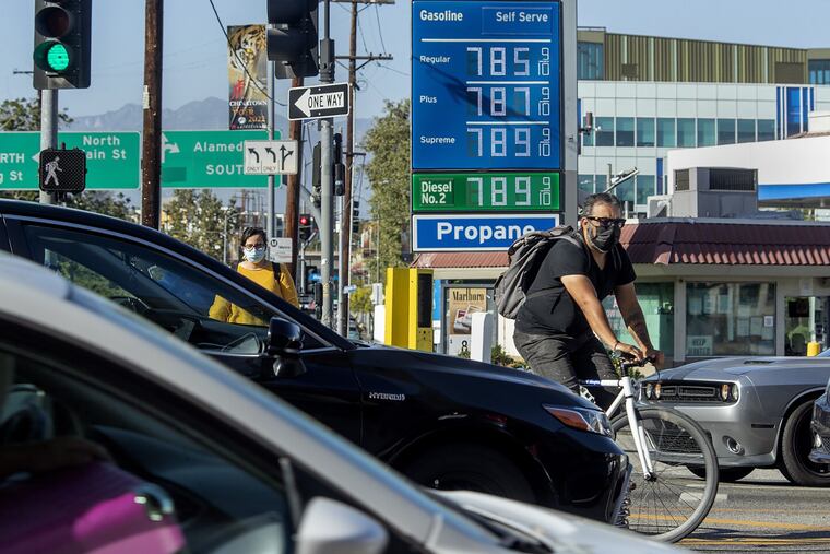 A bicycle rider maneuvers around motorists stuck in traffic in downtown Los Angeles on Friday, where the price of gasoline approaches close to $8 a gallon.