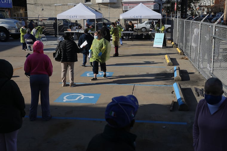 People wait in line to be tested for COVID-19 at Vine Memorial Baptist Church in West Philadelphia on Saturday, Nov. 21, 2020. Staff from Philly Fighting COVID and the Children's Hospital of Philadelphia offered free testing organized by the traveling Community-Accessible Testing & Education (CATE) program, which offers testing at different sites across Pennsylvania.