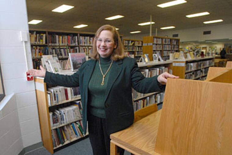 The Glassboro branch of the Gloucester County library system, which used to be an Acme, had to make changes and will try to make more. Carol Wolf, branch manager, shows off one of the two windows in the building. ( April Saul / Staff Photographer )