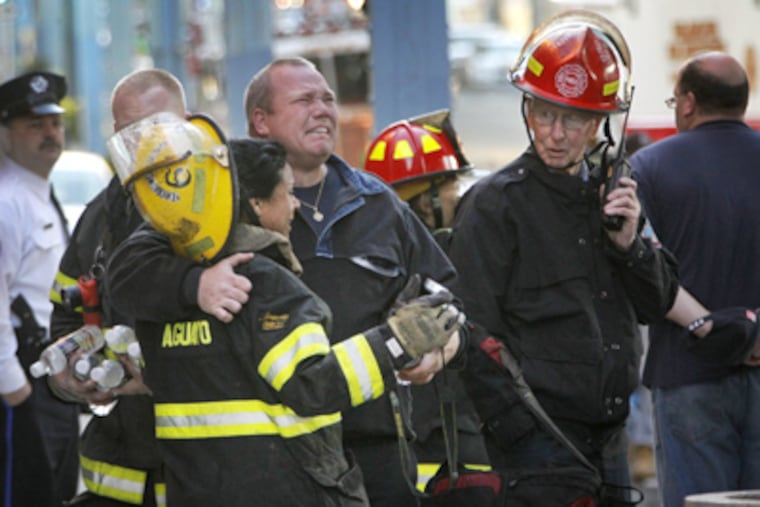 Philadelphia firefighters mourn the loss of their two comrades at the scene of the warehouse fire in Kensington. (Alejandro A. Alvarez / Staff Photographer)
