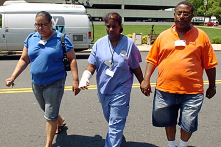 Members of the victim's family enter St. Christopher's Hospital for Children to visit the girl. (Sarah J. Glover / Staff Photographer)