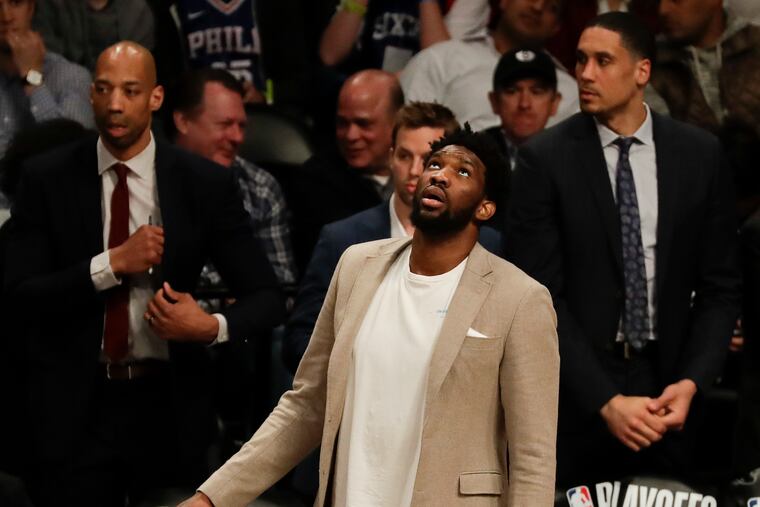Sixers center Joel Embiid looks up at the scored board during a break against the Brooklyn Nets in game three of the Eastern Conference playoffs on Thursday, April 18, 2019 in Brooklyn. Embiid did not play in the game.