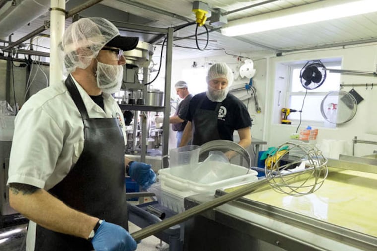 At Caputo Bros. Creamery, Wade Smith prepares to cut the curd with a tool called a chitarra as new employee Bill McGinnis watches.
