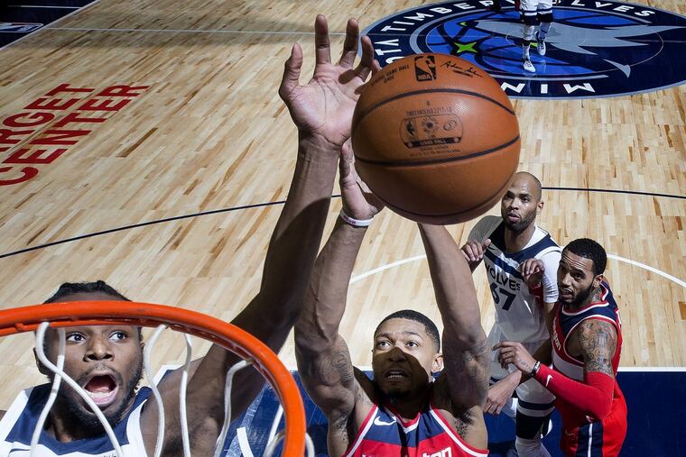 The Wizards' Bradley Beal (middle) and Timberwolves' Andrew Wiggins (left) fight for a rebound in the second half Tuesday.