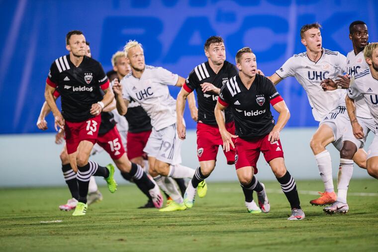 D.C. United and New England Revolution players watching the ball come toward them during the first half.