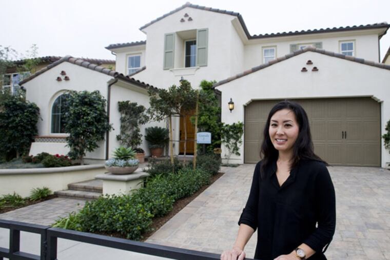 Janet Son stands in front of a model home, October 23, 2013, just like the one she and her family recently purchased in the Montserrat development in Brea, a move-up from their smaller home also in Brea, California. (Sam Gangwer/Orange County Register/MCT)