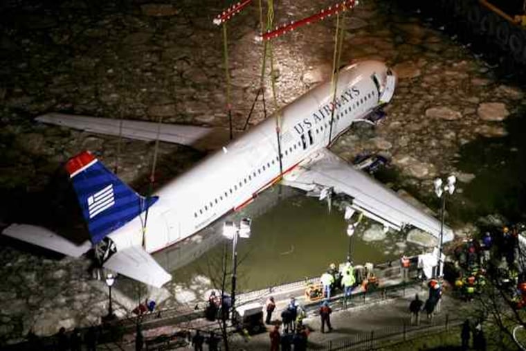 A crane lifts the jet out of the Hudson River and onto a barge. NTSB Officials said that sonar teams may have located one of the two engines and that the other was still attached after all.