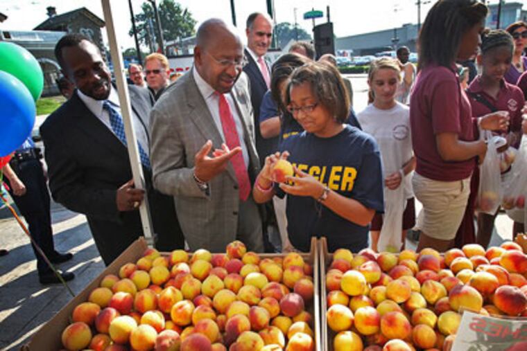 Sharla Weaver, 12,a student at Ziegler Elementary, helps Mayor Nutter pick out a peach. (Alejandro A. Alvarez / Staff Photographer)