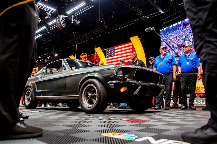 People surround the 1968 "Bullitt" Mustang GT car, Friday, Jan 10, 2020 in Kissimmee, Fla. The iconic Highland Green 1968 Mustang GT that once made history for its appearance in the film “Bullitt” is now making history again. It fetched $3.74 million Friday at Mecum’s Kissimmee auction, making it the most expensive Mustang ever sold. (Patrick Connolly/Orlando Sentinel via AP)