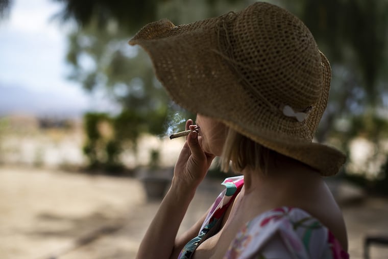 Chevyn McClintock enjoys a joint on the back patio at the pot friendly Desert Hot Springs Inn in Desert Hot Springs, Calif. McClintock spilts her time between New York and Desert Hot Springs. Since Californians legalized the recreational use of marijuana, a handful of hotels began to advertise themselves as pot-friendly lodging.