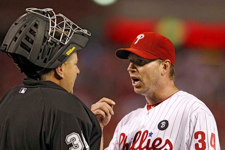 Phillies starter Roy Halladay confers with home plate umpire Gary Cederstrom after the first inning in Game 5 of the 2011 NLDS. ( Ron Cortes / Staff Photographer )