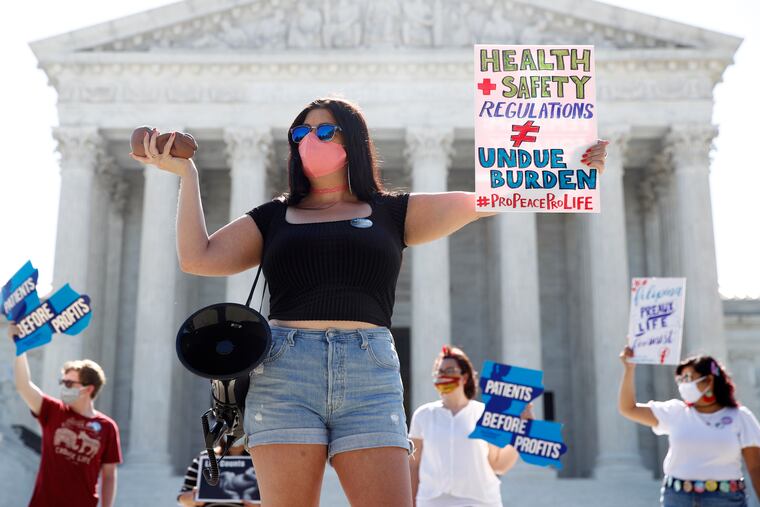 Terrisa Bukovinac, founder of Pro-Life San Francisco, holds a model of a fetus as she and other anti-abortion protesters wait outside the Supreme Court for a decision. The Supreme Court has struck down a Louisiana law regulating abortion clinics, reasserting a commitment to abortion rights over fierce opposition from dissenting conservative justices in the first big abortion case of the Trump era.
