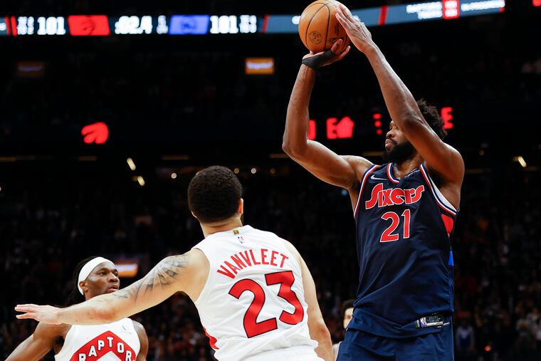Sixers center Joel Embiid shoots the game winning overtime three-point basket past Toronto Raptors guard Fred VanVleet and forward Precious Achiuwa during game three of the first-round Eastern Conference playoffs on Wednesday, April 20, 2022 in Toronto.
