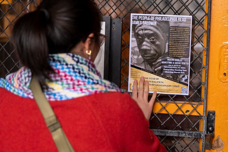 Kathie Jiang posts a flyer about the event before she participates in reading group gathered at Making Worlds Bookstore in West Philadelphia, Sunday, Mar. 10, 2024 to read and discuss the life and writings of James Baldwin. It is part of the city’s “Year of Baldwin” with activities celebrating the year the writer would have turned 100 years old. Organizers at the Saturday Free School have called his work “prophetic” and “revolutionary.”